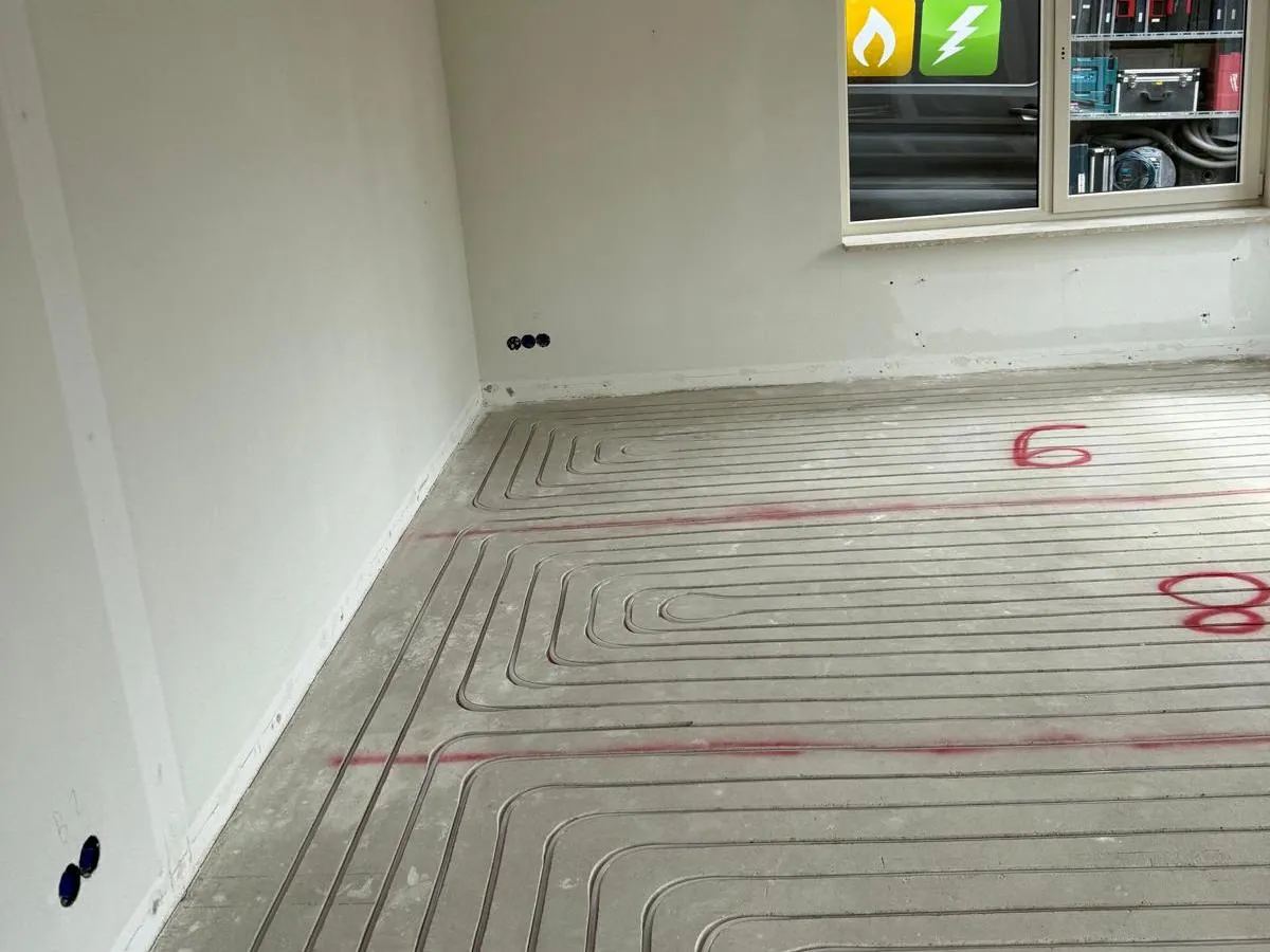 Vloerverwarmingsleidingen over de hele vloer van een woonkamer