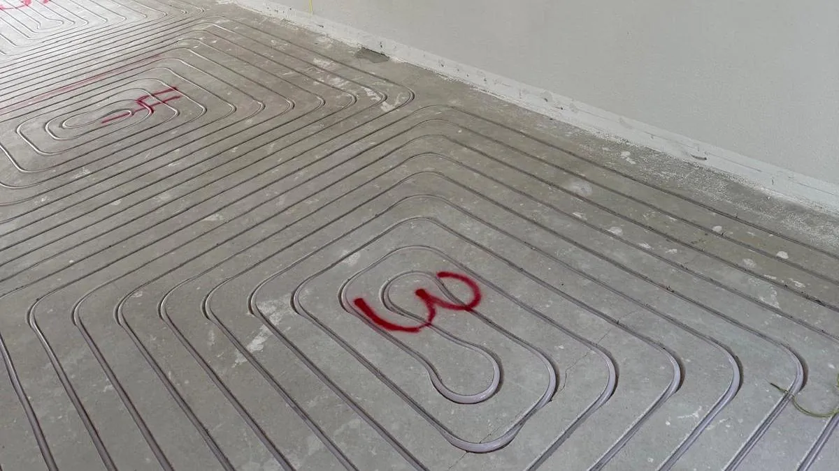 Vloerverwarmingsleidingen op de vloer van een woning